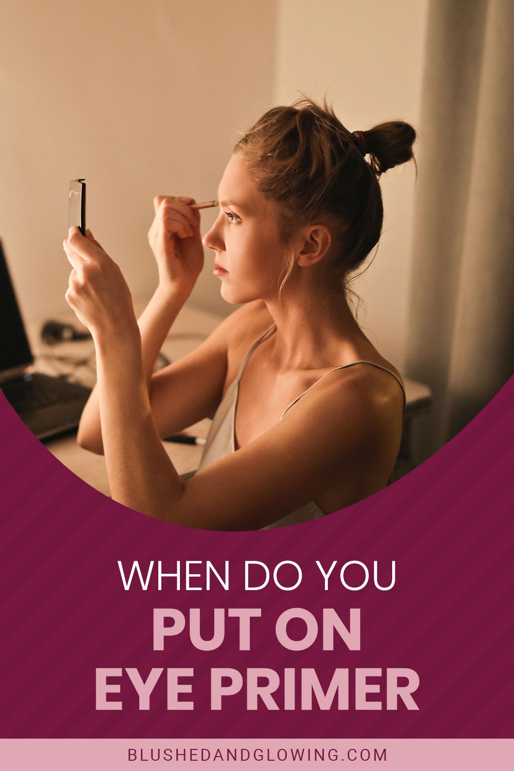 Woman applying makeup with a mirror in one hand and a primer in another - When Do You Put On Eye Primer